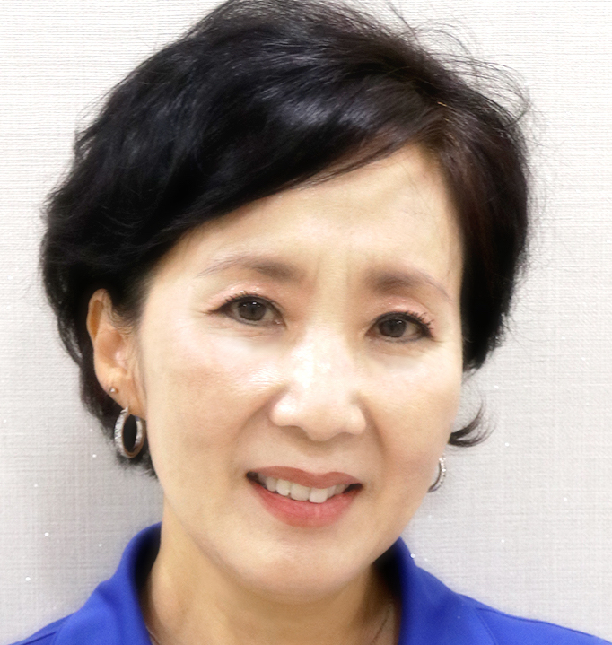 a person with short black hair wearing a blue shirt